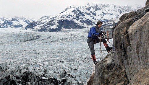 man climbing glacier